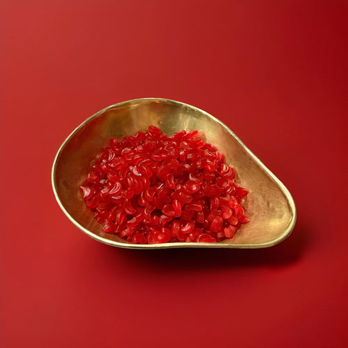 Crescent shaped cherry and floral flavoured cherry lip sweets in a gold bowl with a red background 