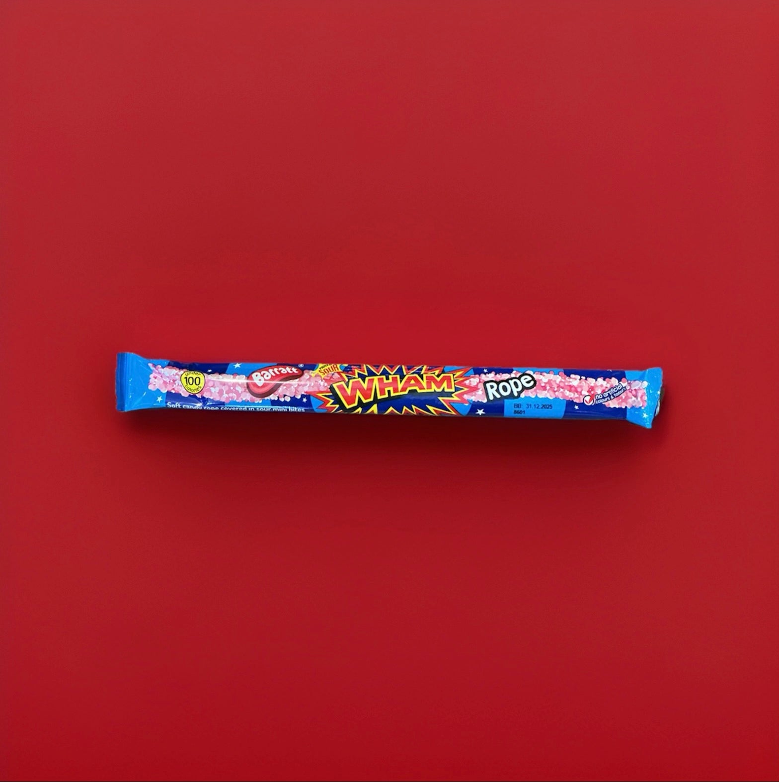 Wrapped long raspberry flavoured jelly sweet with sprinkles on in a blue and red wrapper 