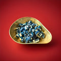 Blue and white coloured rock cuttings with and iron brew flavour in a gold bowl with a red background 