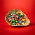 Mixed fruit flavoured hard boiled cushion shaped sweets in a gold bowl with a red background 