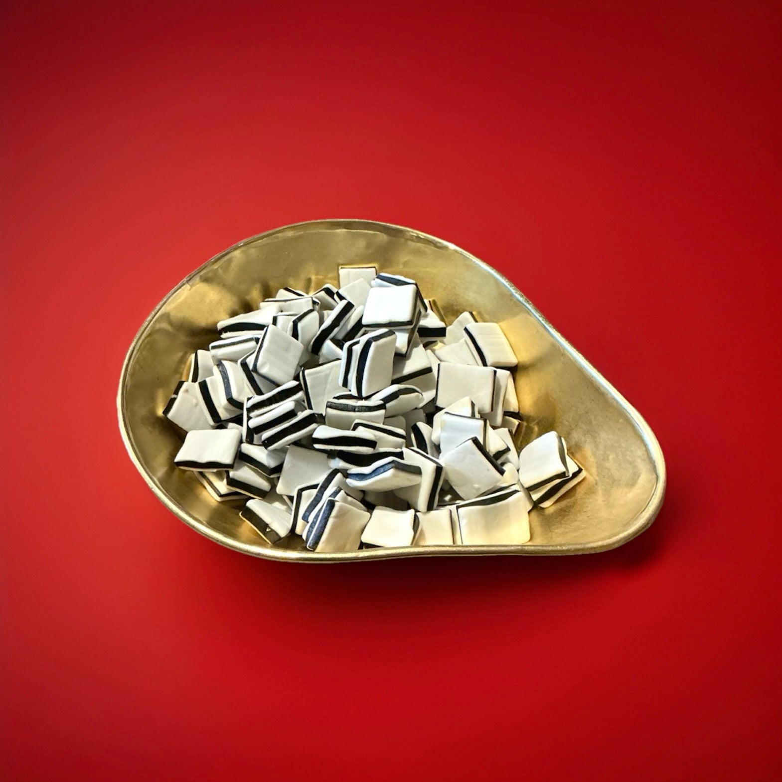 1 kilogram of liquorice and mint fondant black and white mints in a gold bowl with a red background 